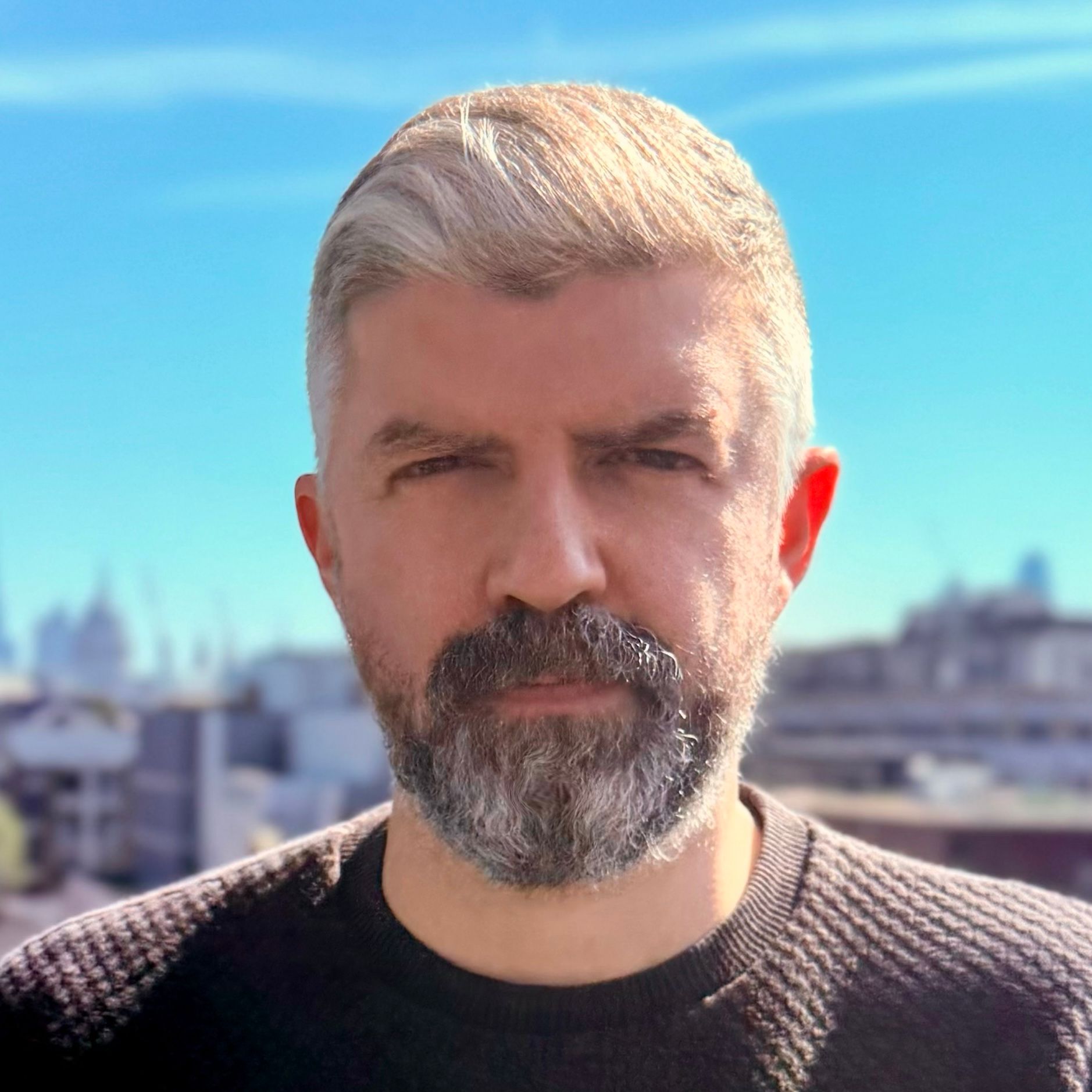 Lee Casey, co-founder and creative director at Hatched, wearing a light blue shirt and holding a microphone, presents on stage.